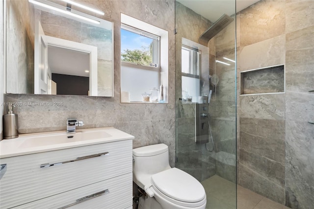 bathroom with vanity, tasteful backsplash, tile walls, toilet, and tiled shower