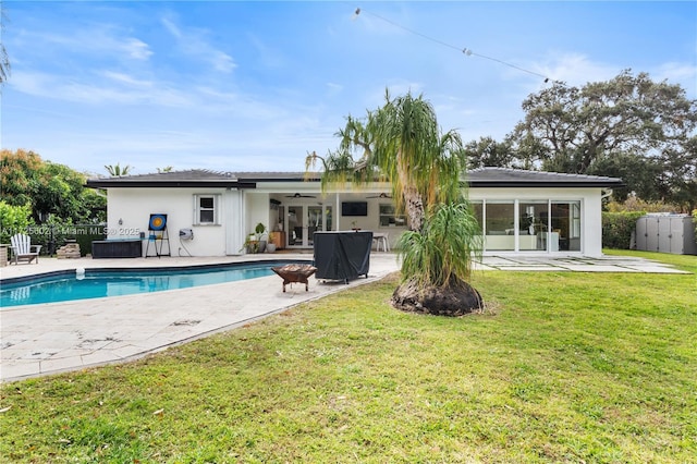 back of property featuring ceiling fan, a fenced in pool, a lawn, and a patio