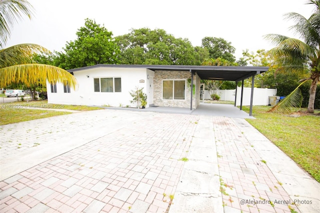 view of front of house with a front yard and a carport