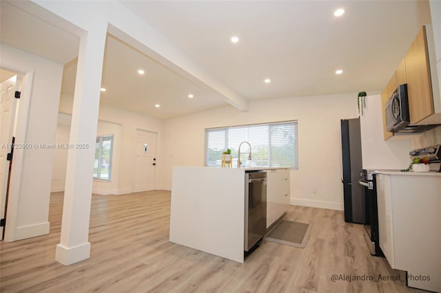 kitchen featuring light hardwood / wood-style floors, stainless steel appliances, lofted ceiling with beams, light brown cabinetry, and sink