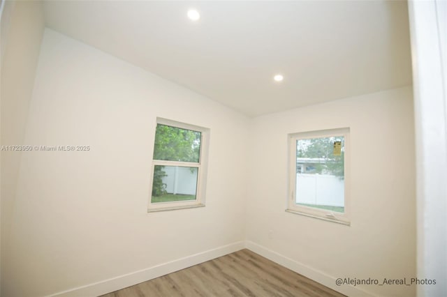 spare room featuring hardwood / wood-style flooring and a wealth of natural light