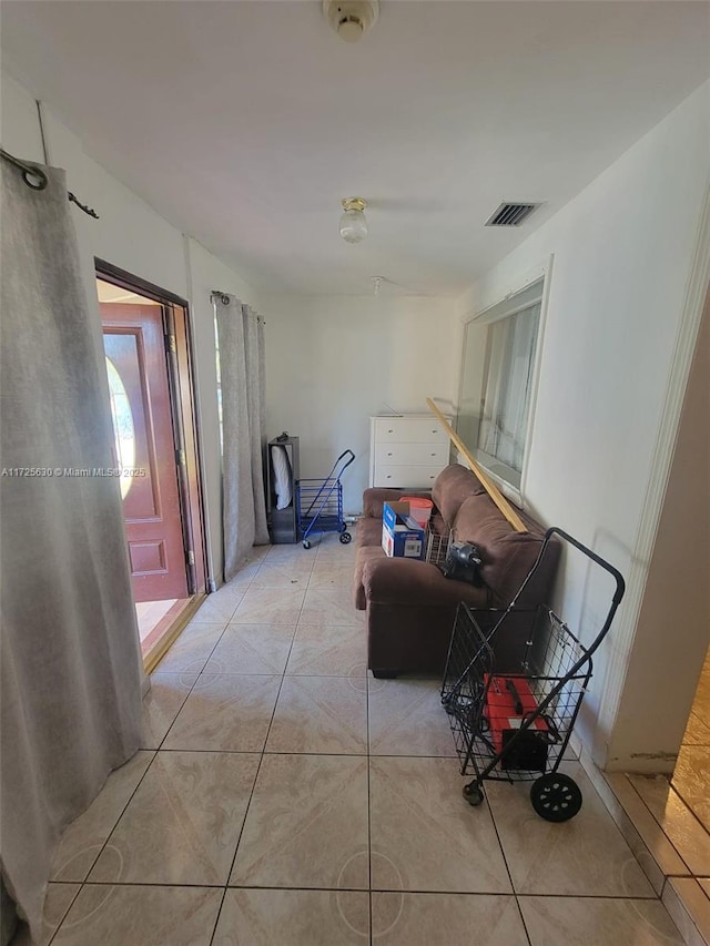 hallway featuring visible vents and light tile patterned flooring