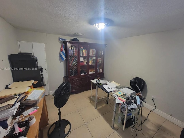 home office with light tile patterned floors, visible vents, and a textured ceiling