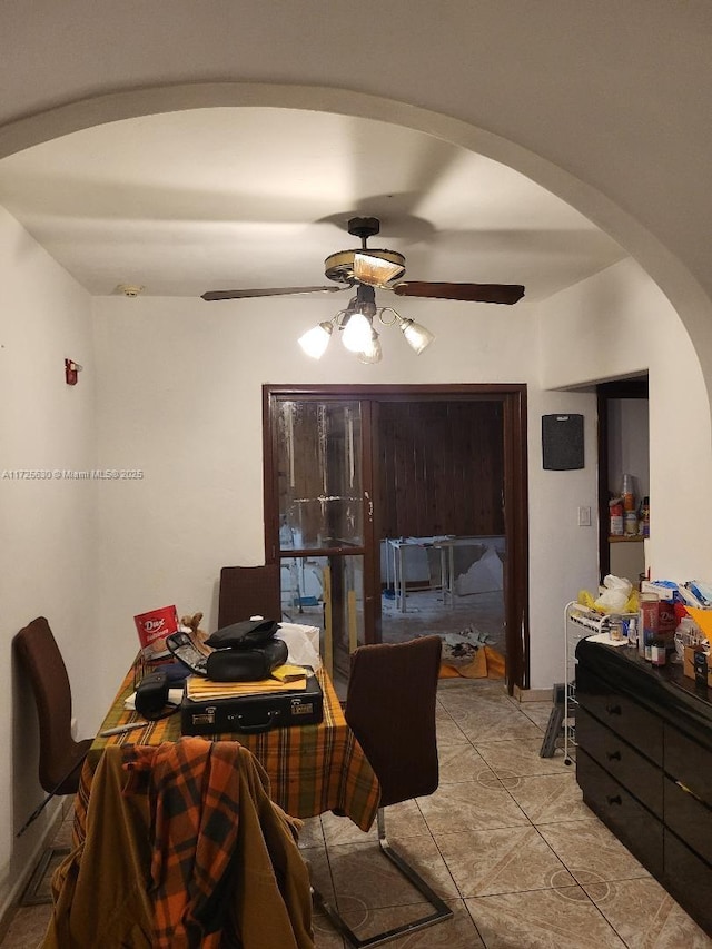 office area with a ceiling fan, arched walkways, and light tile patterned floors