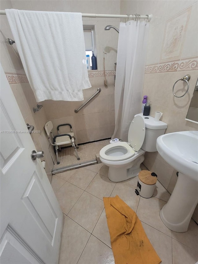 full bath with a tile shower, tile walls, toilet, and tile patterned floors