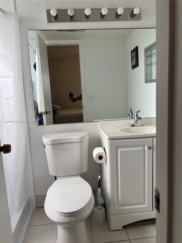 bathroom featuring vanity, tile patterned floors, and toilet