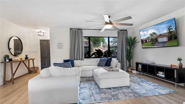 living room featuring ceiling fan and hardwood / wood-style floors