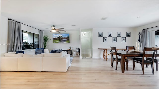 living room featuring ceiling fan and light hardwood / wood-style flooring