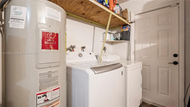 laundry room with electric water heater and washer and clothes dryer