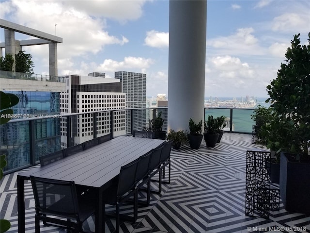 view of patio featuring a balcony and a water view