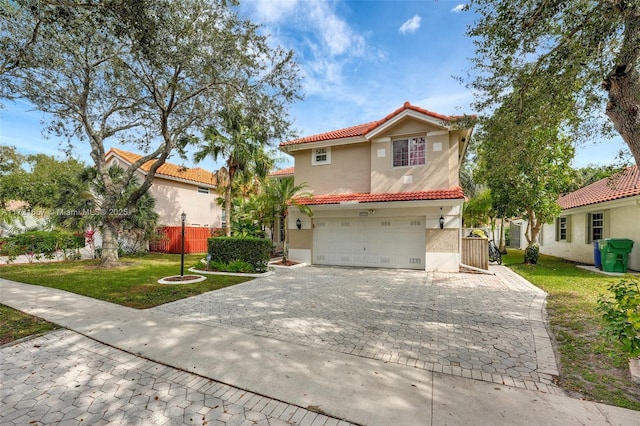 mediterranean / spanish home featuring a front yard and a garage