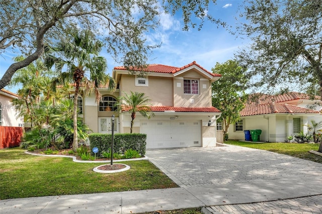 mediterranean / spanish-style house featuring a front yard and a garage