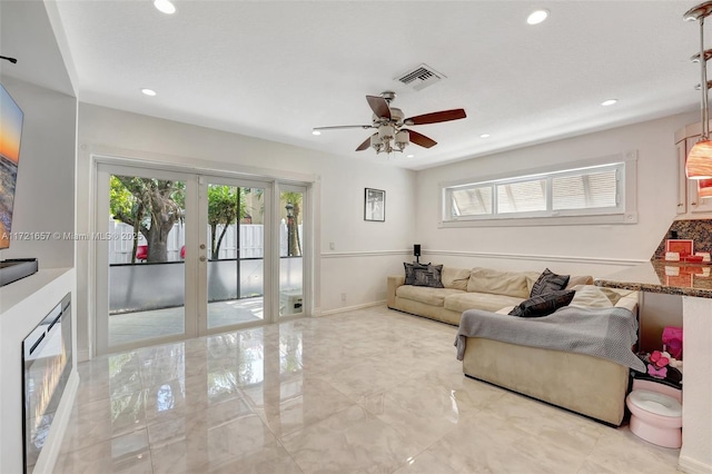 living room featuring ceiling fan and french doors