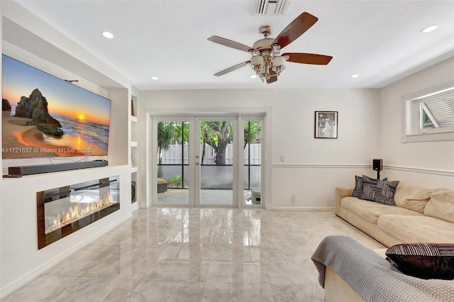 living room featuring ceiling fan, french doors, and built in features