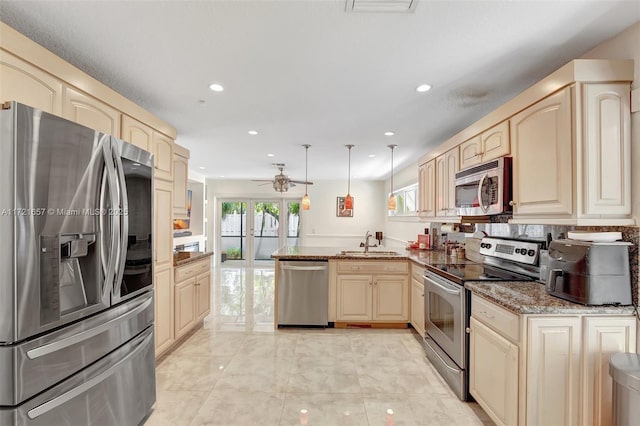 kitchen with stainless steel appliances, sink, decorative light fixtures, ceiling fan, and kitchen peninsula