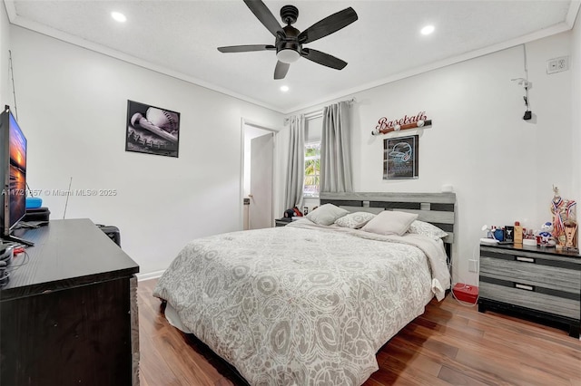 bedroom featuring hardwood / wood-style floors, ceiling fan, and crown molding