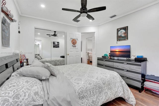 bedroom with a closet, ceiling fan, crown molding, and light hardwood / wood-style flooring