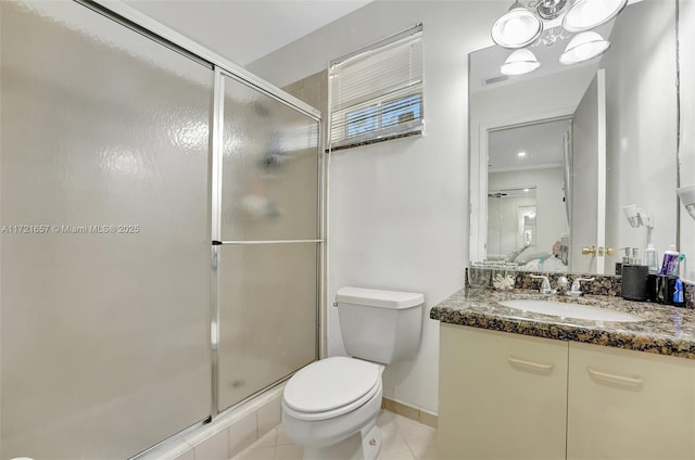 bathroom featuring vanity, toilet, tile patterned floors, and a shower with shower door