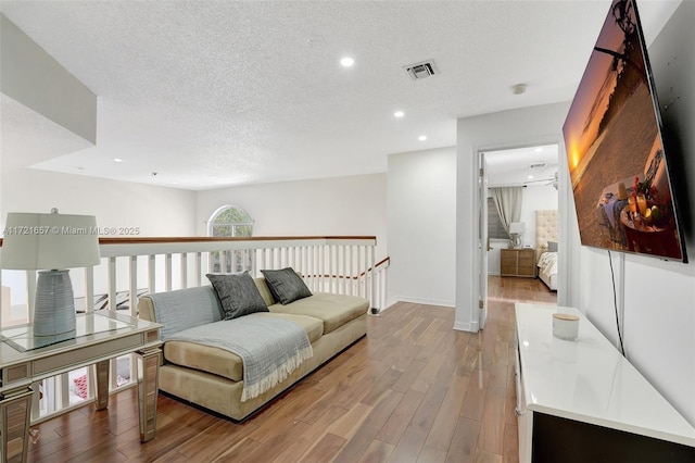 living room with a textured ceiling and hardwood / wood-style floors