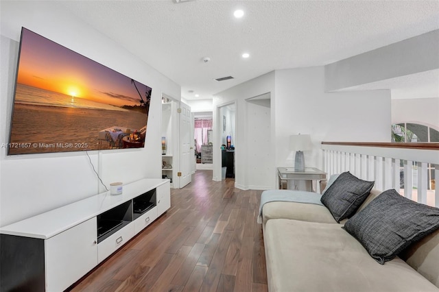 living room with dark wood-type flooring and a textured ceiling