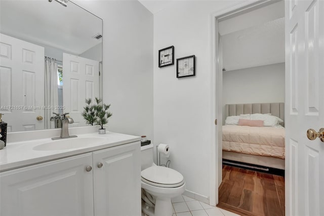 bathroom with toilet, tile patterned flooring, and vanity