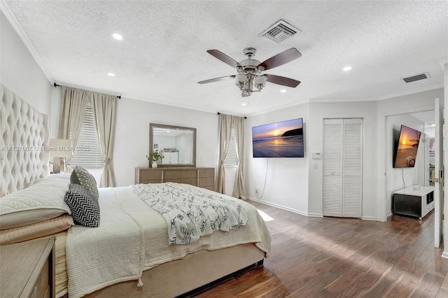 bedroom with a textured ceiling, ceiling fan, crown molding, and dark hardwood / wood-style flooring