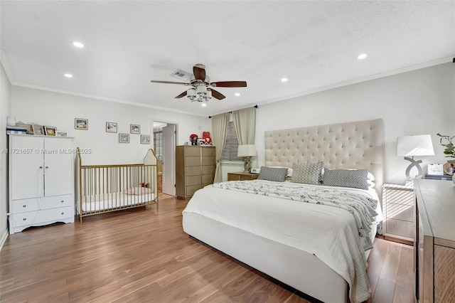 bedroom with ornamental molding, ceiling fan, and wood-type flooring