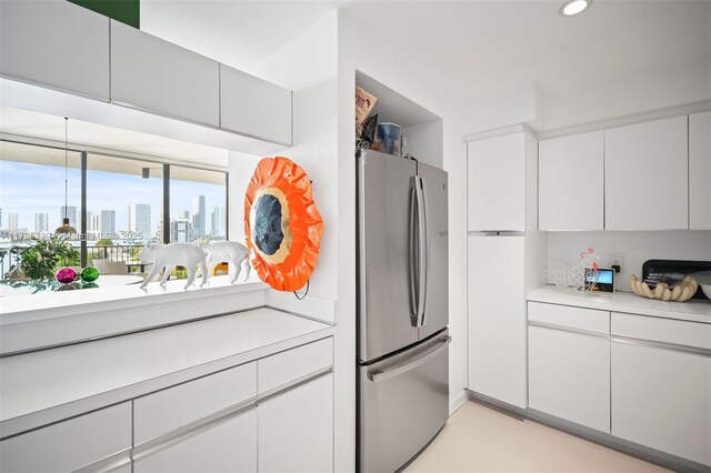 kitchen with appliances with stainless steel finishes, white cabinets, sink, and light tile patterned floors