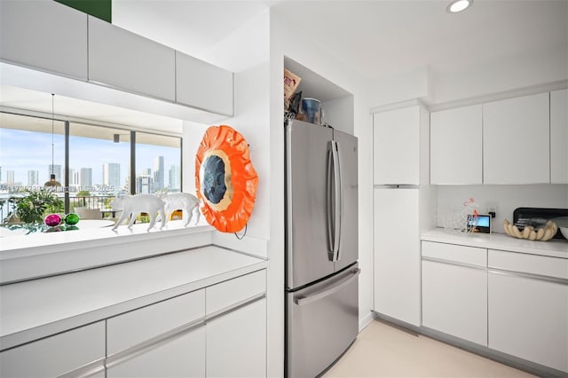 kitchen with white cabinetry and stainless steel refrigerator