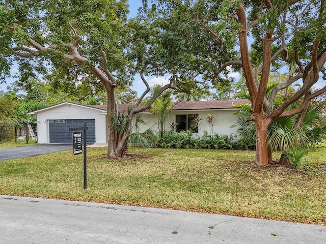 single story home featuring a front yard and a garage