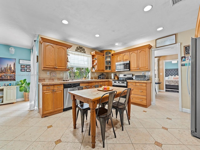 kitchen featuring stainless steel appliances and light tile patterned flooring