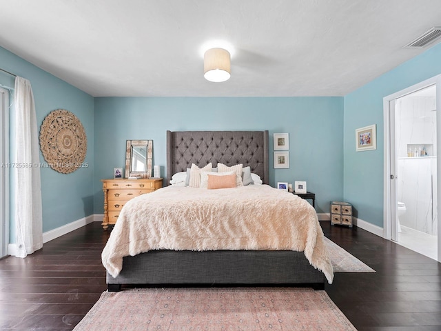 bedroom featuring dark wood-type flooring and ensuite bathroom