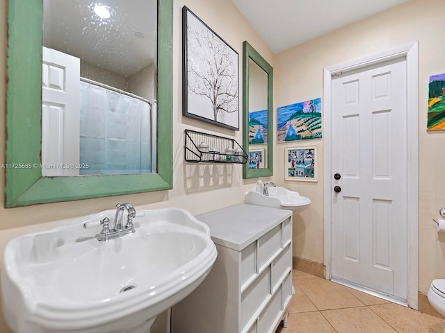 bathroom featuring sink, toilet, and tile patterned floors