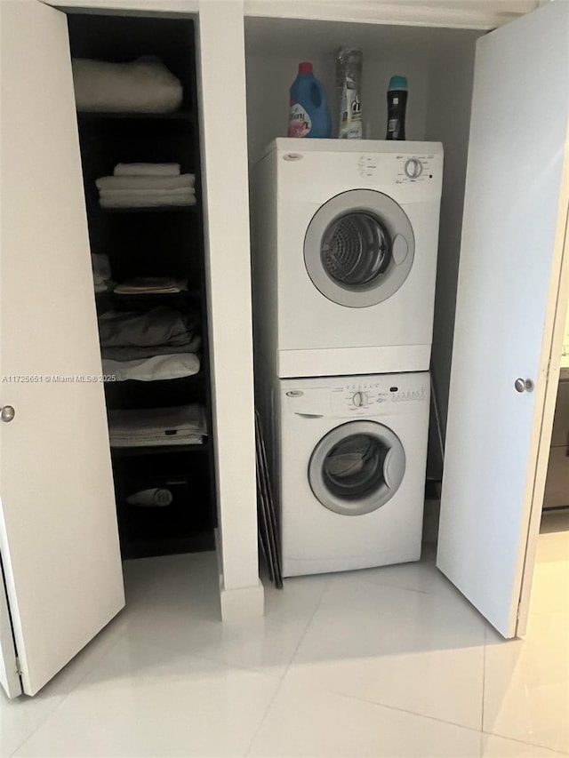 laundry room featuring tile patterned flooring and stacked washer / dryer