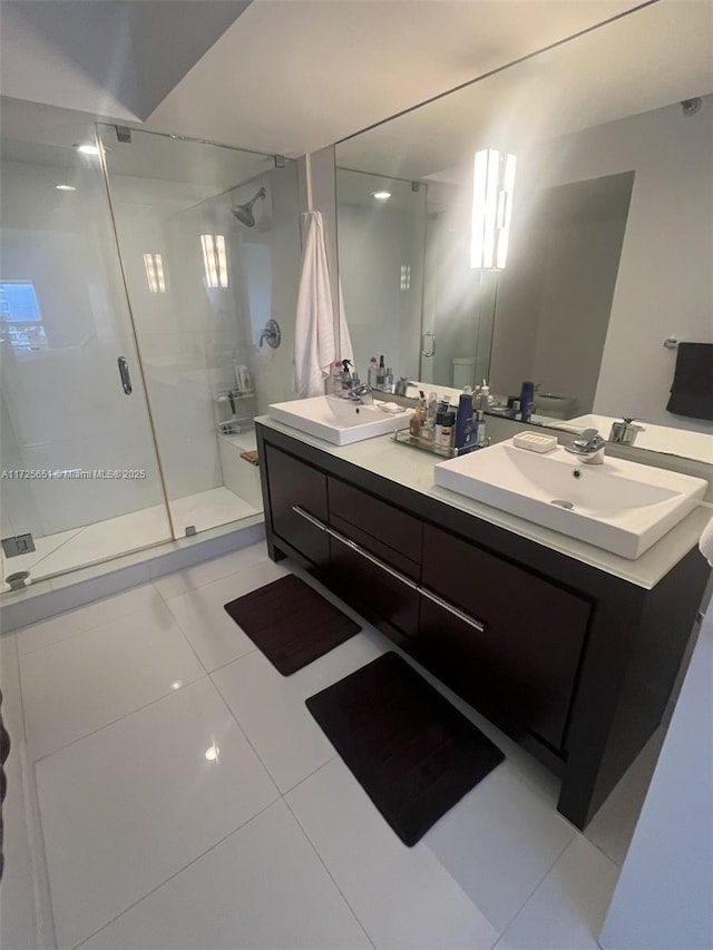 bathroom with a shower with door, vanity, and tile patterned floors