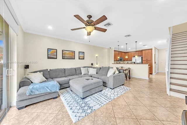 living room featuring ceiling fan, light tile patterned floors, and crown molding