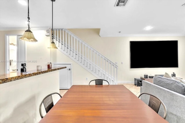 dining room with light tile patterned floors and crown molding