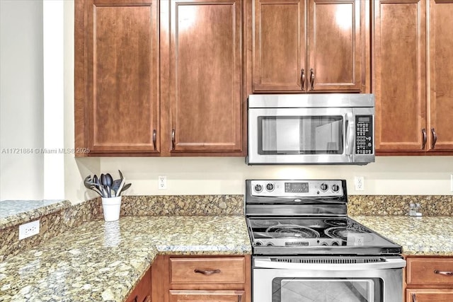 kitchen with appliances with stainless steel finishes and light stone counters