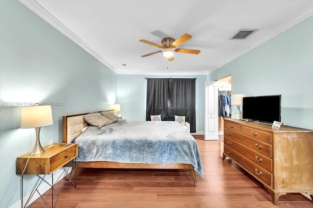 bedroom with a closet, ceiling fan, ornamental molding, and light hardwood / wood-style floors