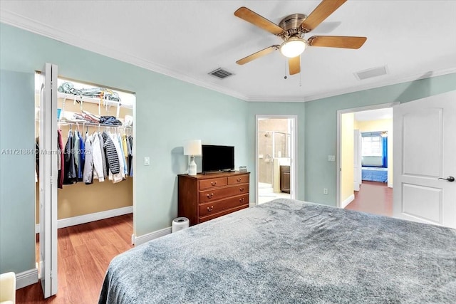 bedroom featuring ensuite bathroom, ceiling fan, light hardwood / wood-style floors, a closet, and a walk in closet