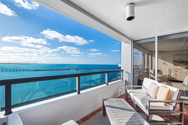 balcony with a water view and an outdoor hangout area