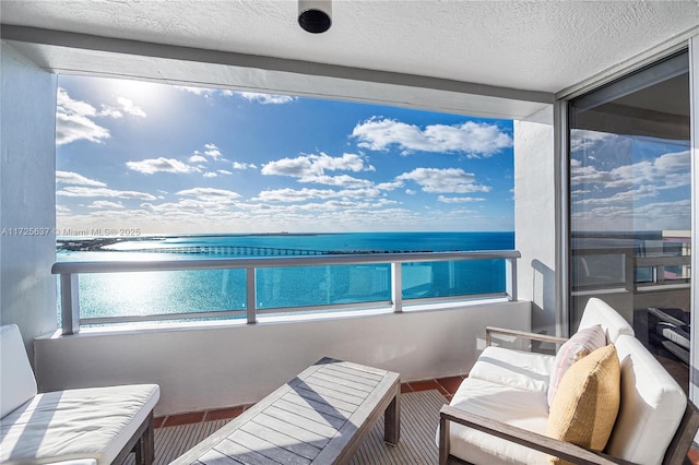 balcony with a water view and an outdoor living space