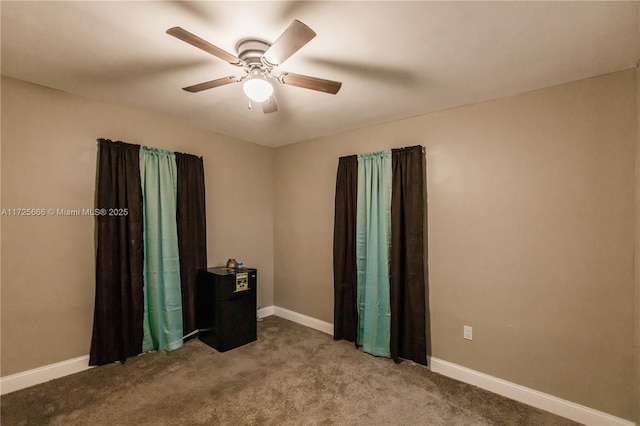 spare room with ceiling fan and carpet