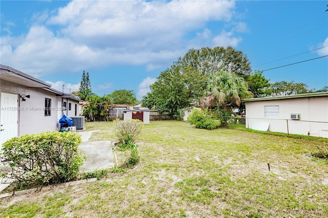 view of yard with a patio, central air condition unit, and a storage shed