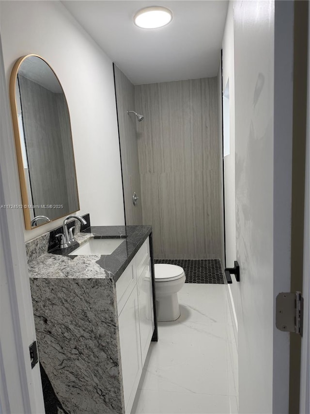 bathroom featuring toilet, walk in shower, and vanity