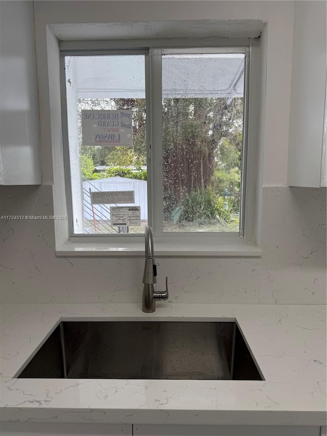 interior details with light stone countertops and sink