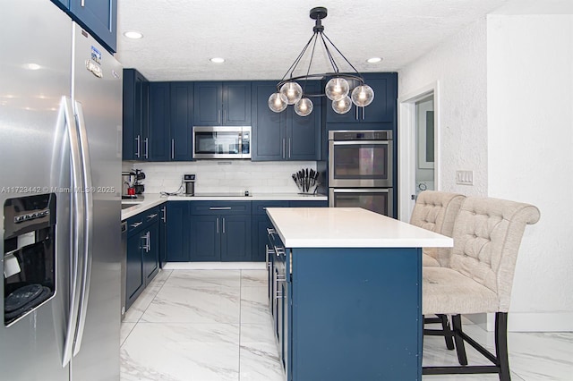 kitchen featuring stainless steel appliances, hanging light fixtures, a center island, a breakfast bar, and blue cabinets