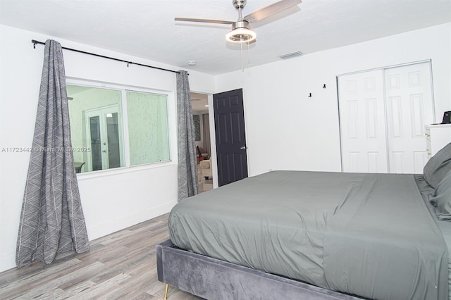 bedroom featuring ceiling fan, light hardwood / wood-style floors, and a closet