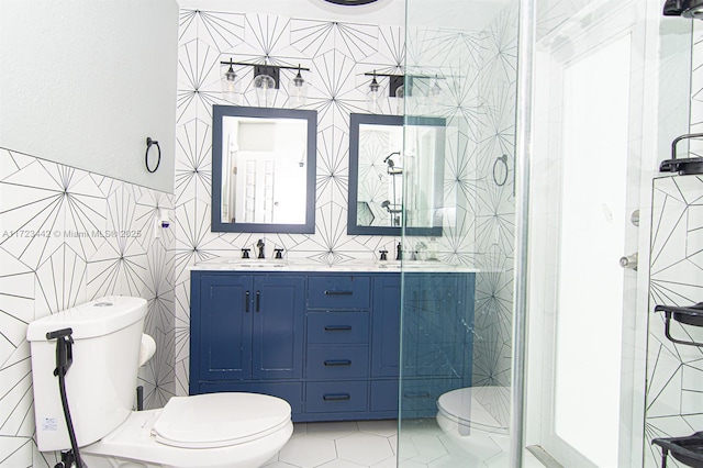 bathroom with toilet, tile patterned floors, vanity, tile walls, and an enclosed shower