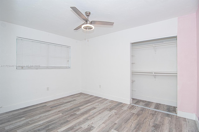 unfurnished bedroom featuring ceiling fan, light hardwood / wood-style floors, and a closet